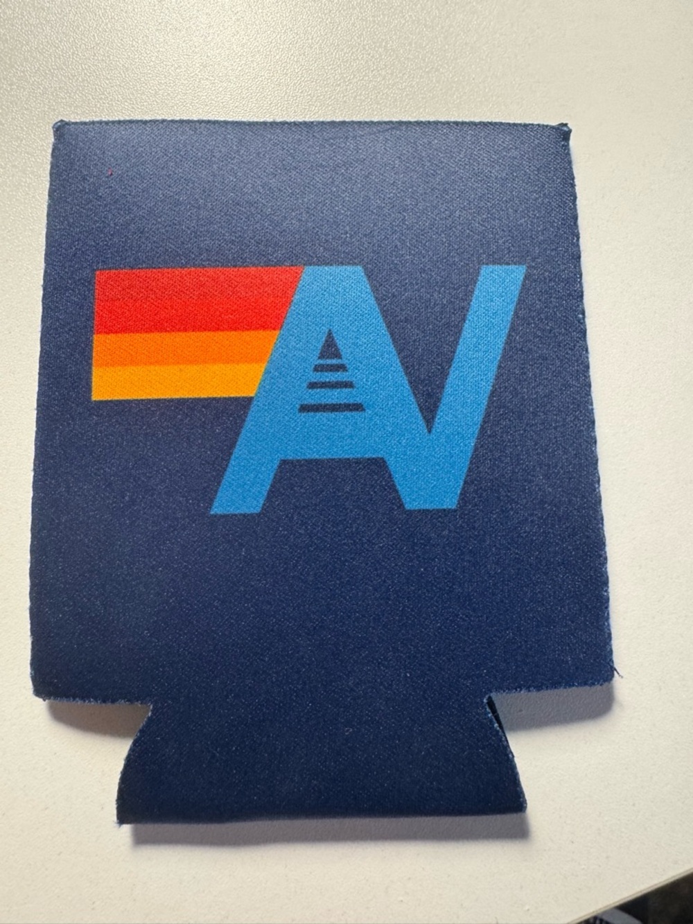 Aviator Nation Navy Can Cooler with Blue Logo and Red-Orange-Yellow Stripe